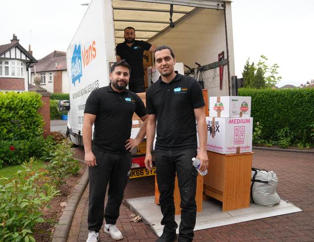 Hello Services removals crew carrying wrapped furniture and boxes out of a house to a Luton van — House removals in Greater Manchester